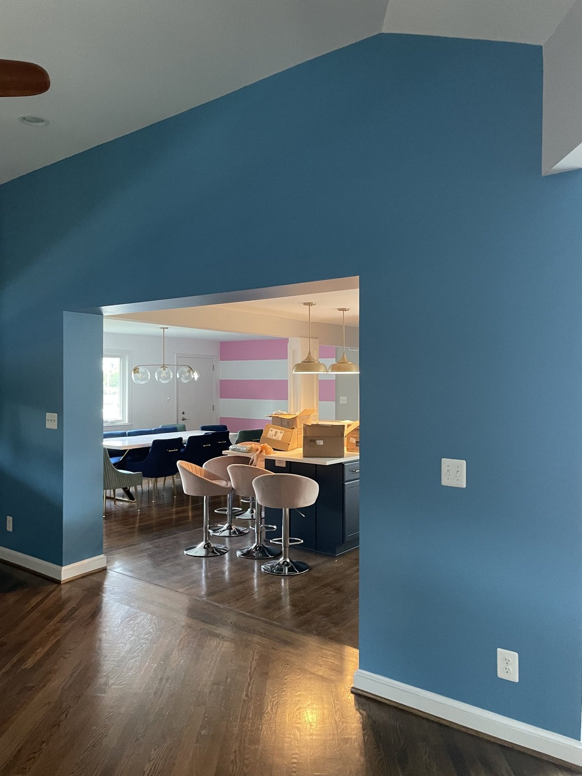 Deep blue accent wall opening to kitchen area